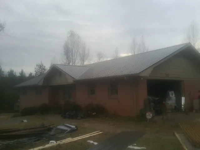 Gray metal roof on a stucco house with an attached garage in Lexington